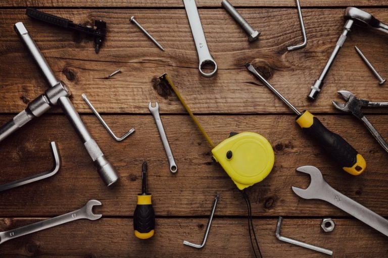 Tools neatly placed on a wooden table, providing a blank space for potential text or design elements.